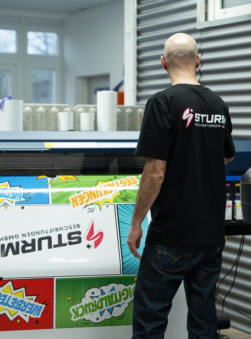 Mitarbeiter druckt einen Aufkleber.