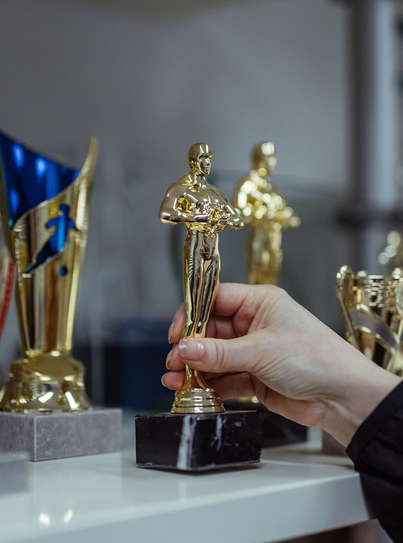 Frau stellt Pokal in den Schrank.